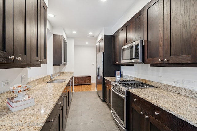 2835 N Lakewood Ave Unit 2C, Chicago, IL 60657 - kitchen with stainless steel appliances, dark brown cabinetry, light stone countertops, recessed lighting, and light tile patterned floors