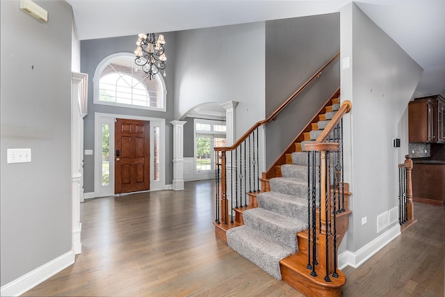 5327 Bamboo Ln, Naperville, IL 60564 - entrance foyer with ornate columns, arched walkways, wood finished floors, a high ceiling, and stairway
