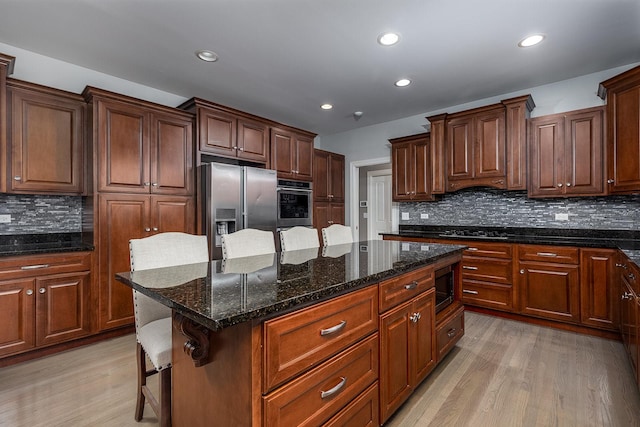 5327 Bamboo Ln, Naperville, IL 60564 - kitchen with appliances with stainless steel finishes, light wood-type flooring, decorative backsplash, a kitchen island, and recessed lighting
