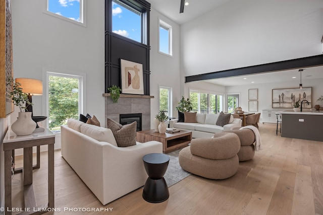 20 Pinnacle Ct, Naperville, IL 60565 - living room featuring a high ceiling, light wood-style floors, a tiled fireplace, and recessed lighting