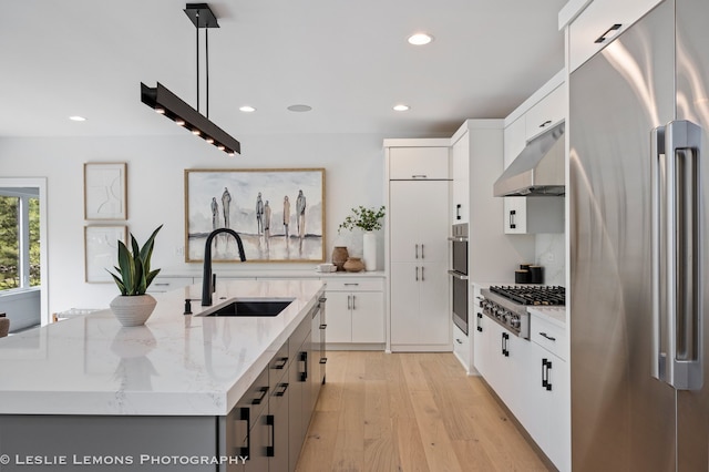20 Pinnacle Ct, Naperville, IL 60565 - kitchen featuring appliances with stainless steel finishes, under cabinet range hood, a center island with sink, light wood-type flooring, and recessed lighting