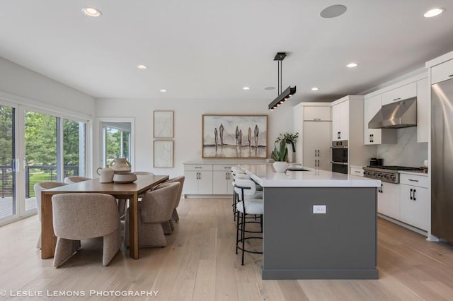 20 Pinnacle Ct, Naperville, IL 60565 - kitchen featuring under cabinet range hood, appliances with stainless steel finishes, white cabinets, recessed lighting, and a center island