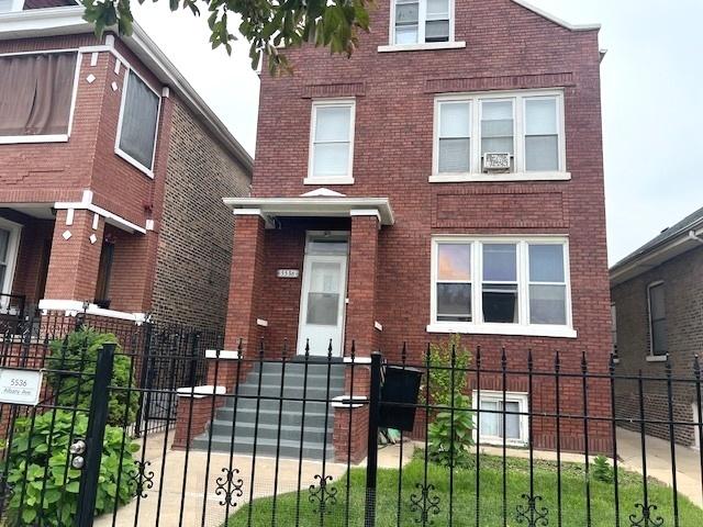 5536 S Albany Ave, Chicago, IL 60629 - view of front facade featuring brick siding and a fenced front yard