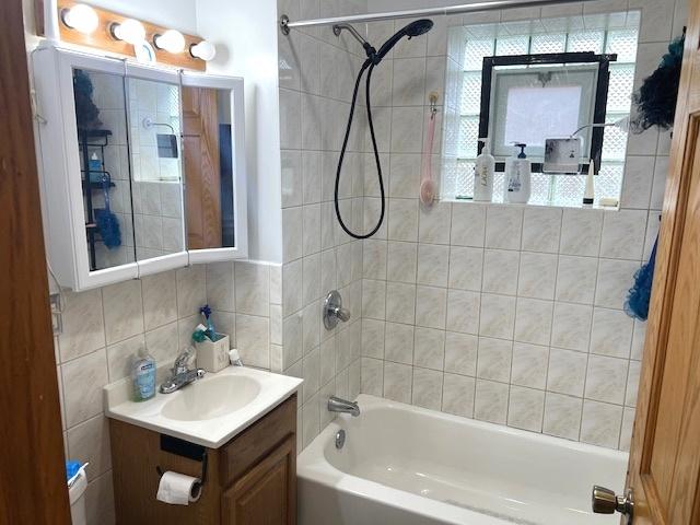 5536 S Albany Ave, Chicago, IL 60629 - bathroom with vanity,  shower combination, tile walls, and tasteful backsplash