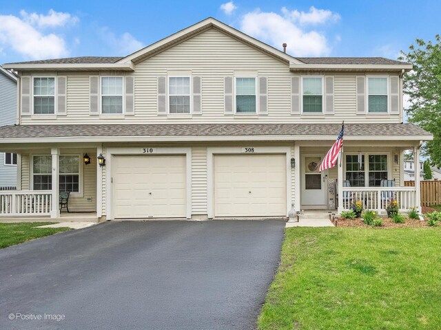 308 Ramsey Dr, Romeoville, IL 60446 - view of property with a porch, asphalt driveway, a front yard, a garage, and roof with shingles