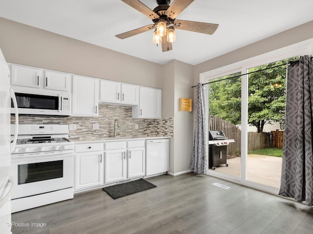 308 Ramsey Dr, Romeoville, IL 60446 - kitchen featuring white appliances, light countertops, tasteful backsplash, white cabinetry, and light wood-style flooring