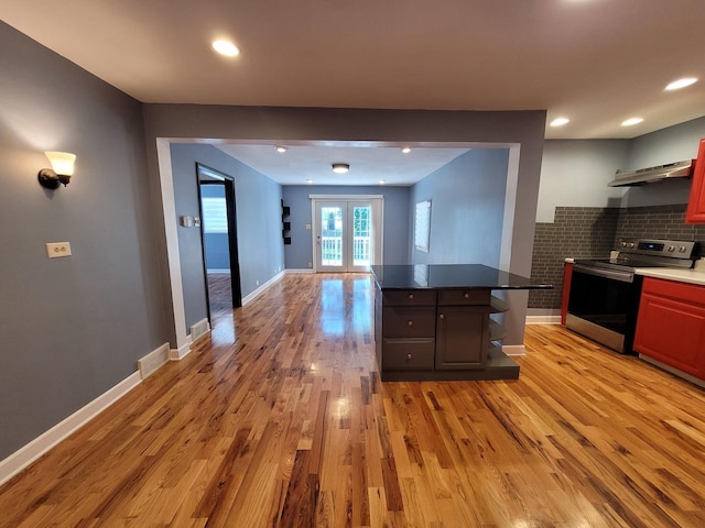 36441 N James Ct, Lake Villa, IL 60046 - kitchen featuring stainless steel electric stove, light wood-style floors, dark countertops, open floor plan, and a kitchen island