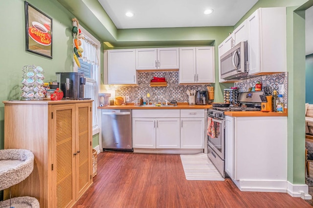 4025 W 24th St, Chicago, IL 60623 - kitchen with stainless steel appliances, wood finished floors, white cabinetry, backsplash, and recessed lighting