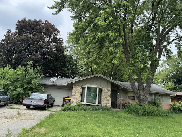 4830 E Lawn Dr, Rockford, IL 61108 - ranch-style house featuring stone siding, a garage, a front lawn, driveway, and board and batten siding