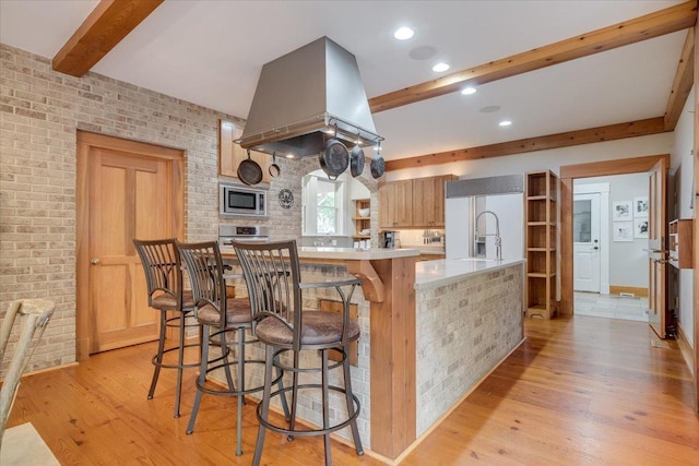 2 Timber Ridge Ln, Mansfield, IL 61854 - kitchen featuring built in appliances, beam ceiling, light countertops, light wood-style flooring, and a breakfast bar area