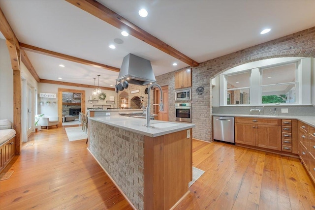 2 Timber Ridge Ln, Mansfield, IL 61854 - kitchen with stainless steel appliances, arched walkways, beamed ceiling, light wood-style flooring, and a center island with sink