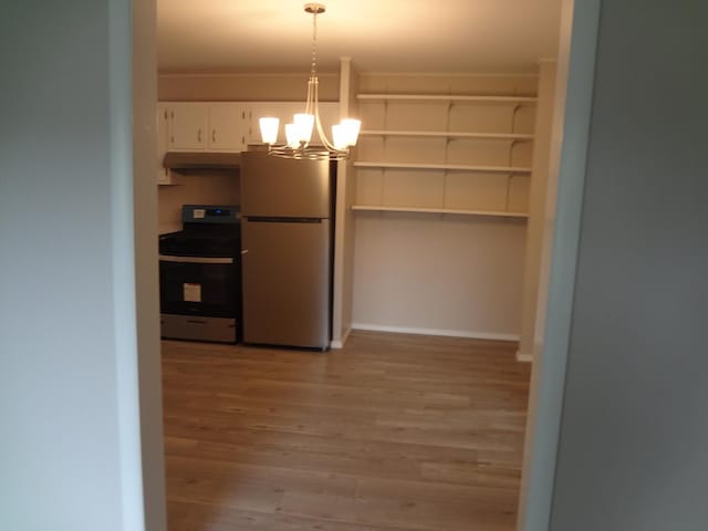 9802 Gallek Rd, Fox River Grove, IL 60021 - kitchen with stainless steel appliances, under cabinet range hood, light wood-type flooring, a chandelier, and white cabinets