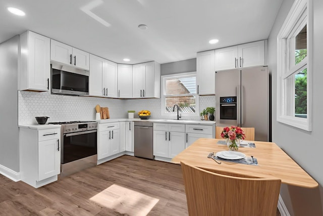 5707 W 82nd Pl, Burbank, IL 60459 - kitchen with appliances with stainless steel finishes, white cabinets, light wood-style flooring, tasteful backsplash, and recessed lighting