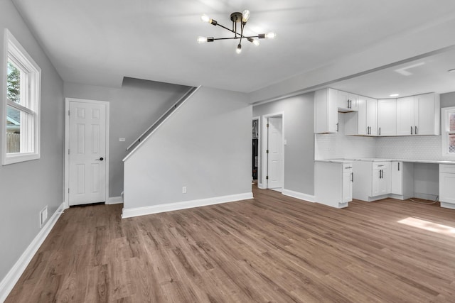 5707 W 82nd Pl, Burbank, IL 60459 - unfurnished living room featuring light wood-style flooring, a chandelier, and stairs