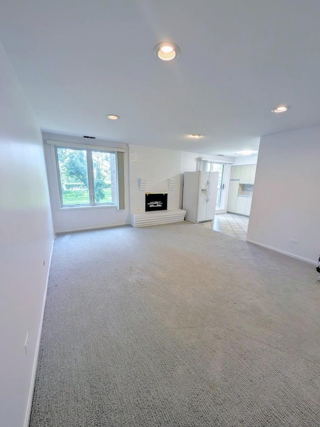1125 Lake Cook Rd Unit 209, Northbrook, IL 60062 - unfurnished living room with light colored carpet, recessed lighting, and a fireplace with raised hearth