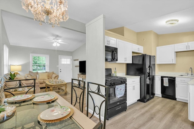 1825 Parkdale Dr, Champaign, IL 61821 - kitchen with black appliances, light wood-type flooring, light countertops, white cabinetry, and lofted ceiling