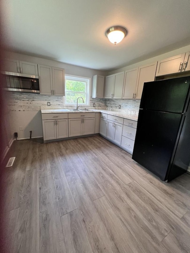 6643 S 13370e Rd, Pembroke Twp, IL 60958 - kitchen with freestanding refrigerator, stainless steel microwave, gray cabinets, light countertops, and decorative backsplash