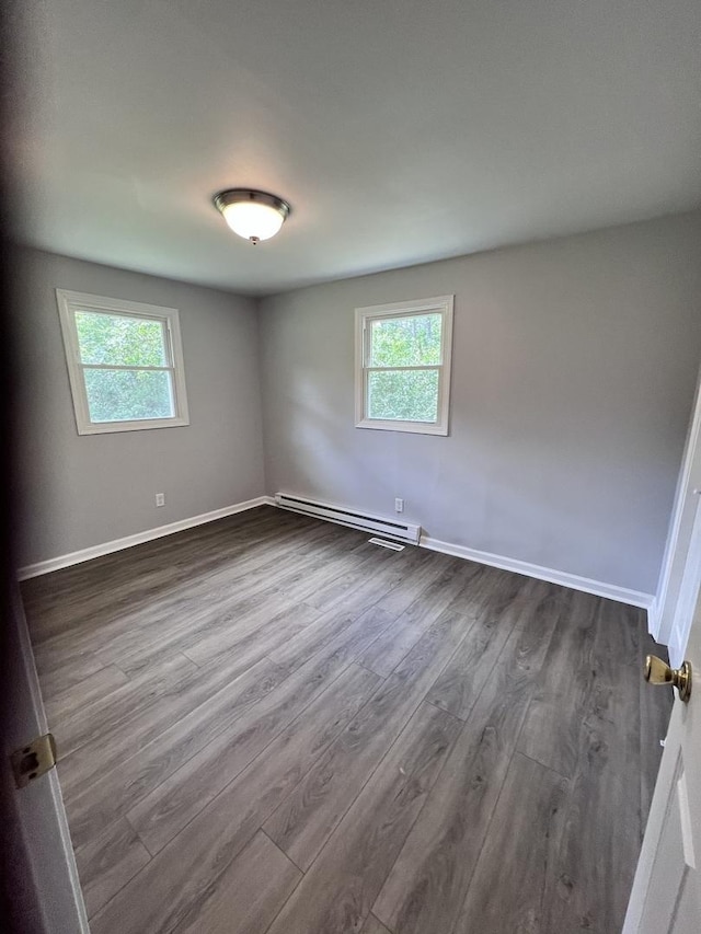6643 S 13370e Rd, Pembroke Twp, IL 60958 - unfurnished room featuring baseboard heating, plenty of natural light, and dark wood-style flooring