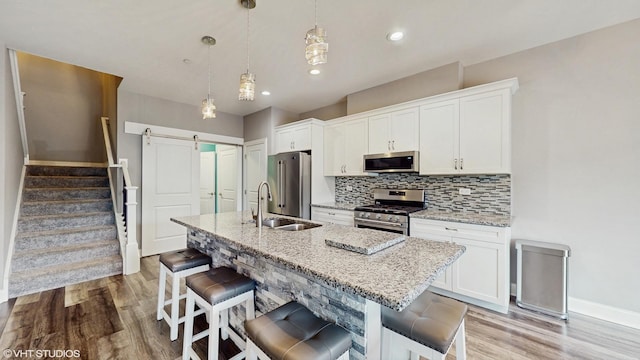 14948 S Preserve Dr, Lockport, IL 60441 - kitchen featuring appliances with stainless steel finishes, light wood-style floors, an island with sink, decorative backsplash, and recessed lighting