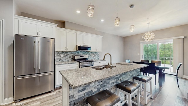 14948 S Preserve Dr, Lockport, IL 60441 - kitchen featuring stainless steel appliances, light wood-style floors, white cabinets, light stone counters, and decorative backsplash