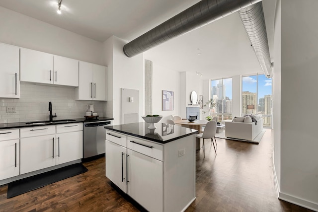 700 N Larrabee St Unit 2010, Chicago, IL 60654 - kitchen featuring stainless steel dishwasher, dark countertops, rail lighting, backsplash, and dark wood finished floors