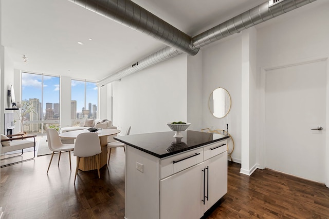 700 N Larrabee St Unit 2010, Chicago, IL 60654 - kitchen featuring dark countertops, a view of skyline, dark wood-type flooring, a center island, and a wall of windows