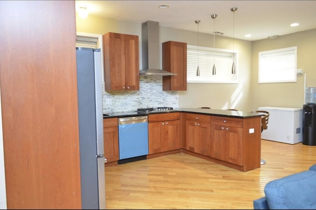 4435 S Oakenwald Ave Unit 1, Chicago, IL 60653 - kitchen featuring wall chimney exhaust hood, appliances with stainless steel finishes, dark countertops, light wood finished floors, and decorative backsplash