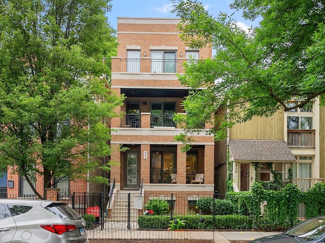 832 W Altgeld St Unit 1, Chicago, IL 60614 - multi unit property featuring a balcony, brick siding, a fenced front yard, and covered porch