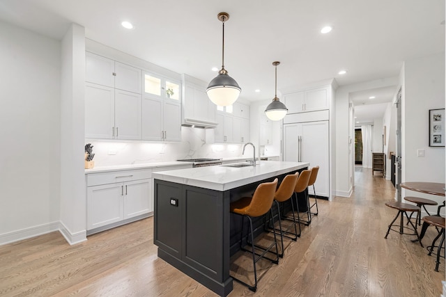 832 W Altgeld St Unit 1, Chicago, IL 60614 - kitchen with white cabinets, light countertops, a kitchen island with sink, recessed lighting, and a kitchen bar