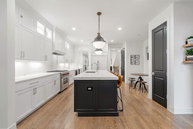 832 W Altgeld St Unit 1, Chicago, IL 60614 - kitchen featuring luxury range, white cabinetry, light wood-type flooring, a center island with sink, and recessed lighting