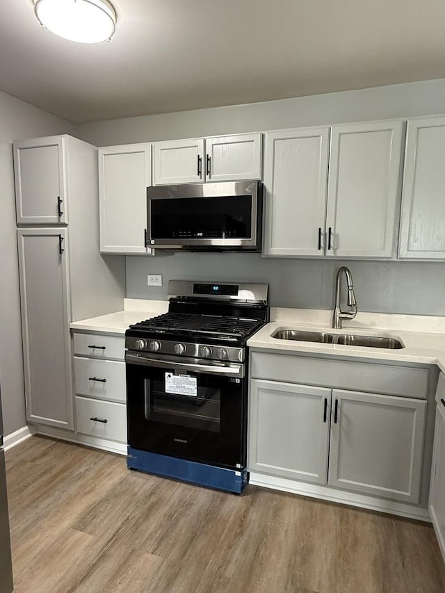907 Gael Dr Unit D, Joliet, IL 60435 - kitchen featuring stainless steel appliances, light countertops, light wood-type flooring, and white cabinetry