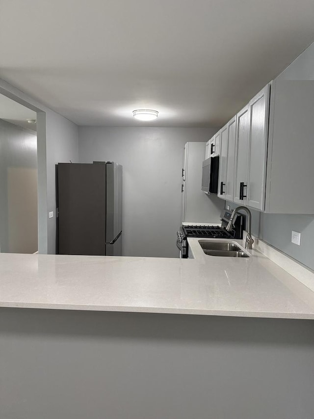 907 Gael Dr Unit D, Joliet, IL 60435 - kitchen with stainless steel appliances, light countertops, and a peninsula