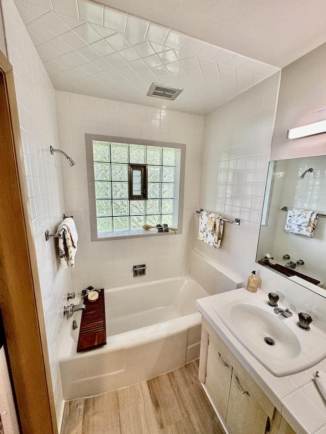 221 Thornbrook Rd, Dekalb, IL 60115 - full bathroom with wood finished floors, a bathtub, vanity, and tile walls