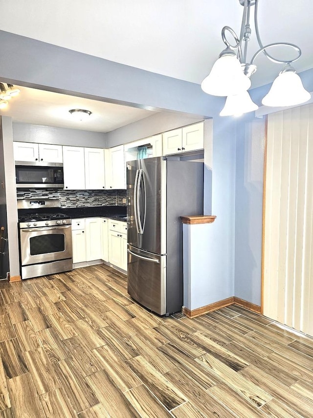 6512 Ridge Dr, Chicago Ridge, IL 60415 - kitchen featuring stainless steel appliances, wood finished floors, white cabinets, and dark countertops