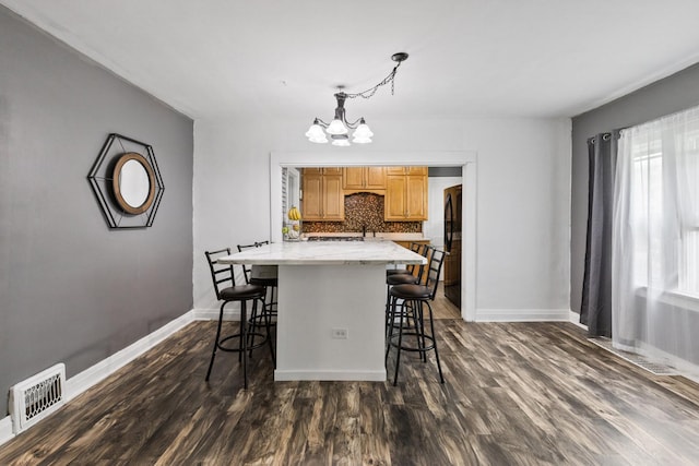956 S Elm Ave, Kankakee, IL 60901 - kitchen with a chandelier, a kitchen bar, tasteful backsplash, freestanding refrigerator, and dark wood finished floors
