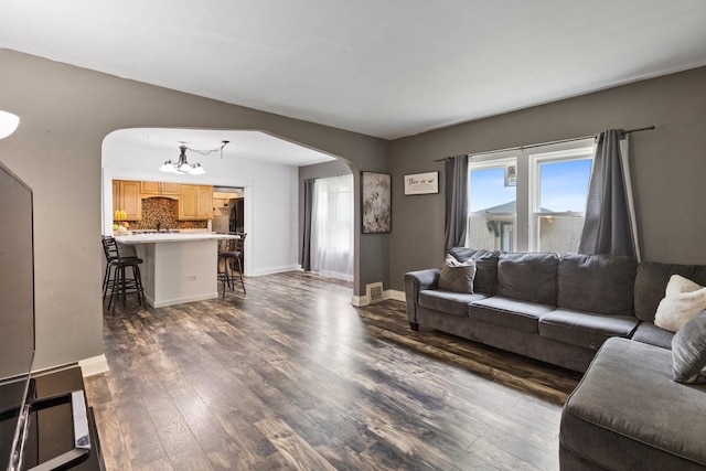 956 S Elm Ave, Kankakee, IL 60901 - living area with arched walkways, a chandelier, and dark wood-style flooring