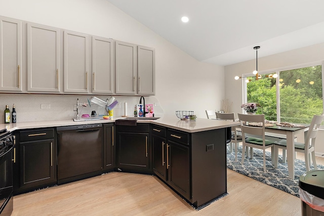 1602 Peachtree Ln, Lockport, IL 60441 - kitchen featuring black appliances, a peninsula, light wood-style floors, lofted ceiling, and light countertops