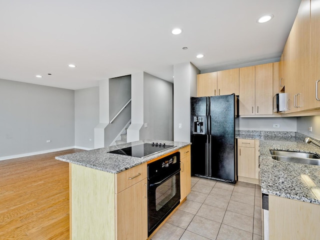 737 W Washington Blvd Unit 3003, Chicago, IL 60661 - kitchen with black appliances, light brown cabinets, light stone countertops, a center island, and recessed lighting
