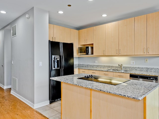 737 W Washington Blvd Unit 3003, Chicago, IL 60661 - kitchen featuring black appliances, light brown cabinetry, recessed lighting, a kitchen island, and light stone counters
