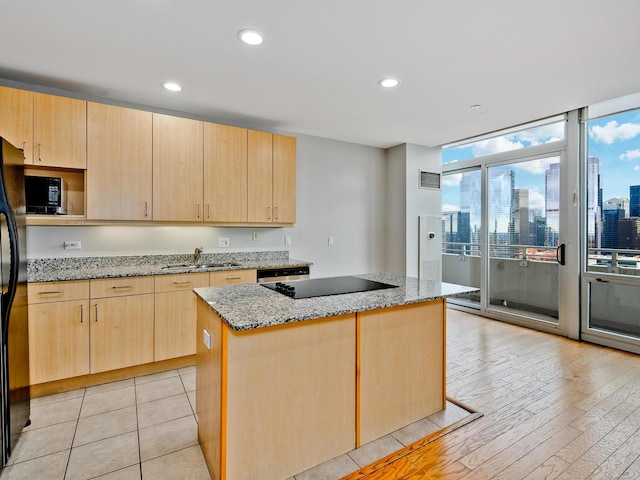 737 W Washington Blvd Unit 3003, Chicago, IL 60661 - kitchen with light brown cabinetry, black appliances, a kitchen island, light stone countertops, and a skyline view