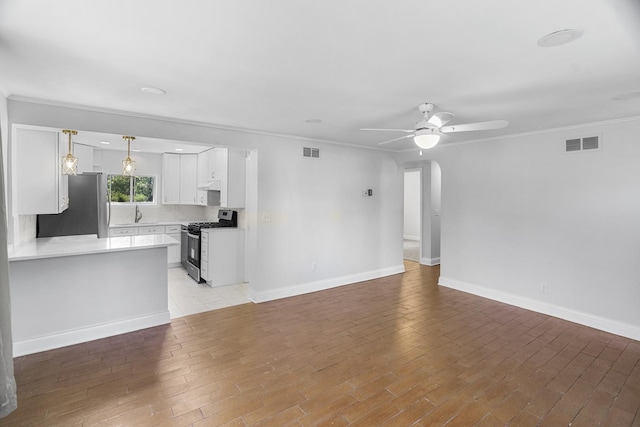 930 S Chatham Ave, Addison, IL 60101 - unfurnished living room featuring ceiling fan, ornamental molding, arched walkways, and light wood-type flooring
