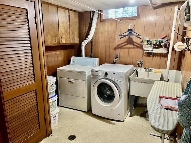 336 Flossmoor Ave, Waukegan, IL 60085 - laundry area with washing machine and clothes dryer, wooden walls, cabinet space, and light floors