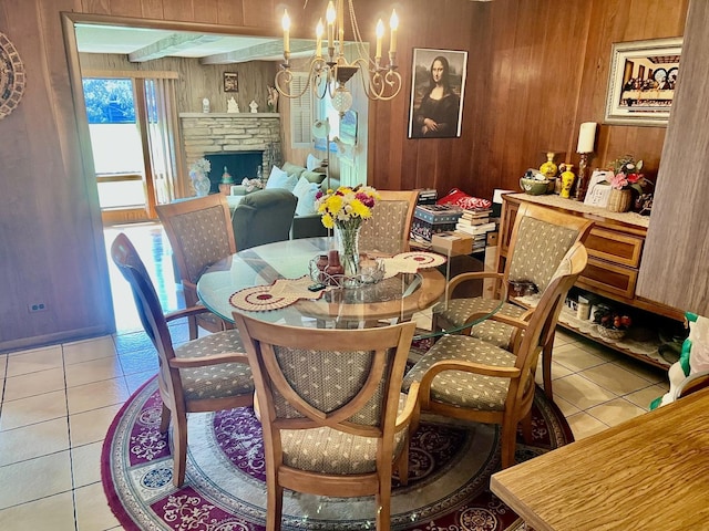 336 Flossmoor Ave, Waukegan, IL 60085 - dining space with wooden walls, light tile patterned flooring, a fireplace, and a chandelier