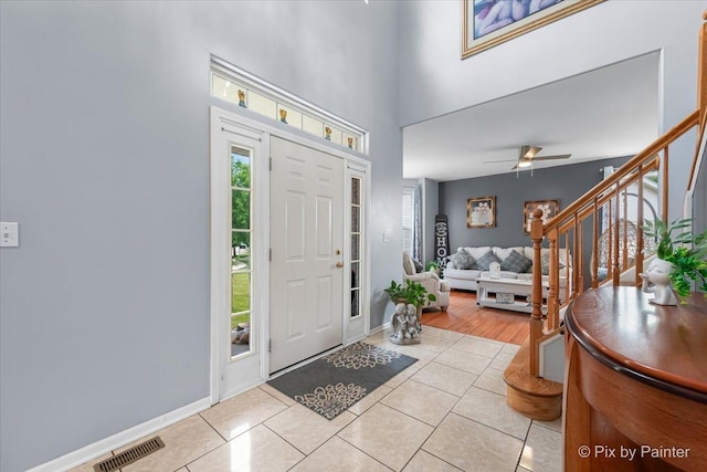 28909 Honeysuckle Ct, Lakemoor, IL 60051 - entryway with light tile patterned floors, stairway, a high ceiling, and a ceiling fan