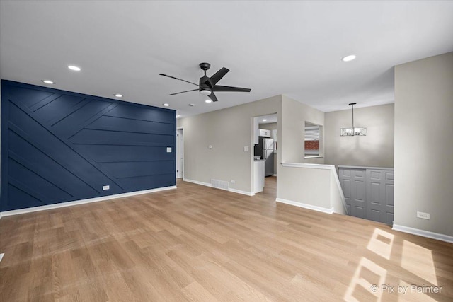 6710 Valley View Rd, Hanover Park, IL 60133 - unfurnished living room with light wood-type flooring, ceiling fan, recessed lighting, and a chandelier