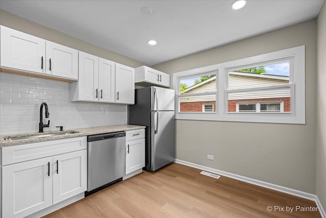 6710 Valley View Rd, Hanover Park, IL 60133 - kitchen featuring stainless steel appliances, light wood finished floors, backsplash, white cabinetry, and light stone counters