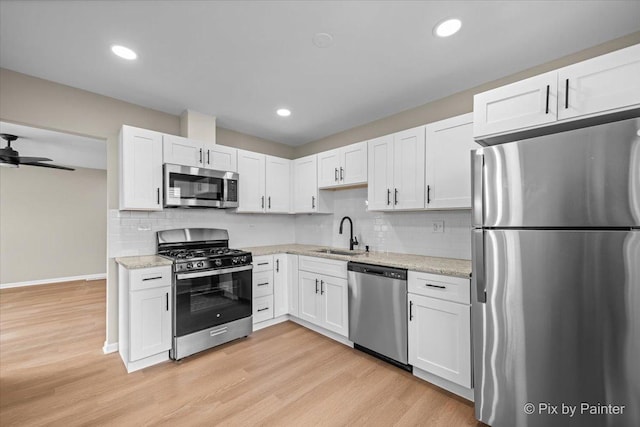 6710 Valley View Rd, Hanover Park, IL 60133 - kitchen with stainless steel appliances, white cabinets, light wood-type flooring, decorative backsplash, and recessed lighting