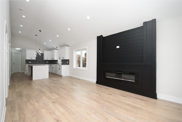 8402 S Carpenter St, Chicago, IL 60620 - unfurnished living room featuring light wood-style floors, lofted ceiling, and recessed lighting