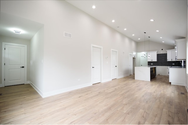 8402 S Carpenter St, Chicago, IL 60620 - unfurnished living room with high vaulted ceiling, light wood-type flooring, and recessed lighting