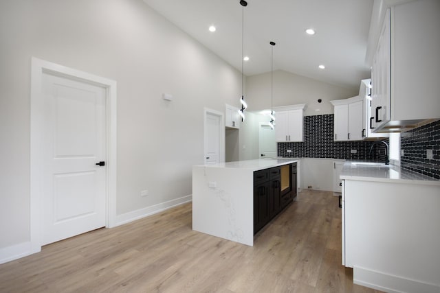 8402 S Carpenter St, Chicago, IL 60620 - kitchen with light wood-style flooring, tasteful backsplash, hanging light fixtures, white cabinetry, and high vaulted ceiling